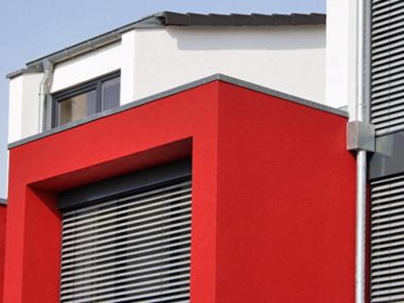 Maison rouge et blanche avec des volets gris