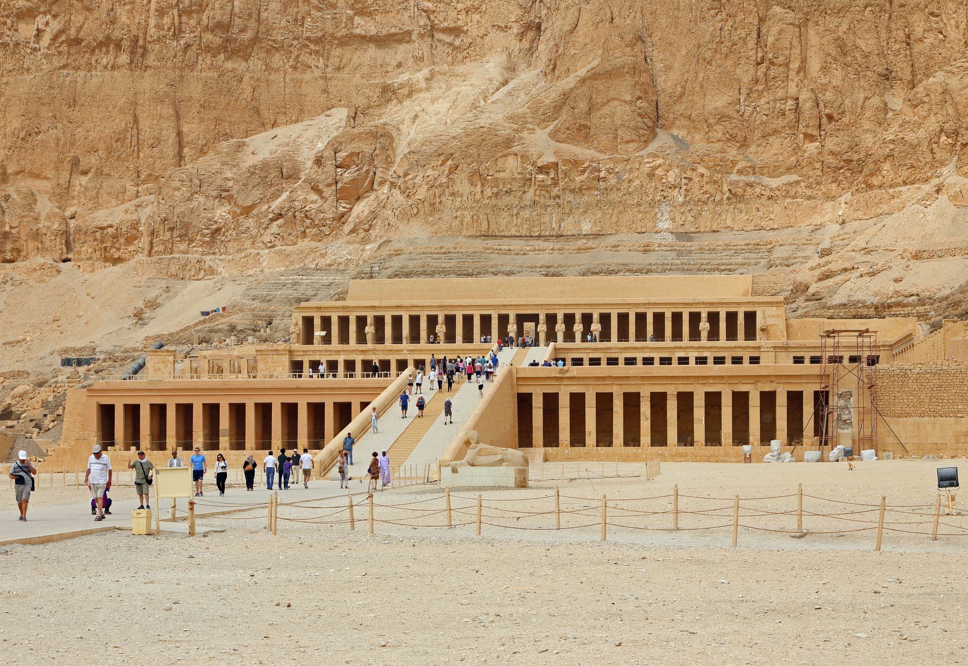 Temple of Hatshepsut, Luxor, Egypt, with columns, ramps, and people against a tan cliff backdrop.