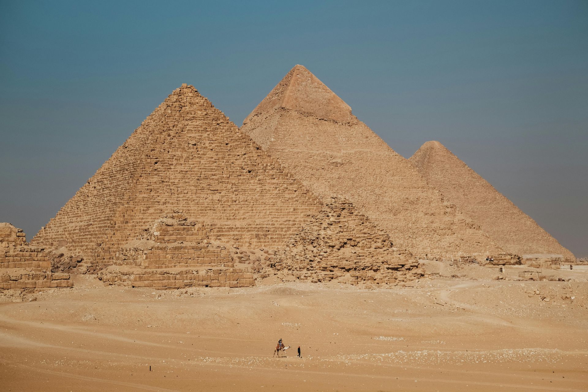 Pyramids of Giza in the desert, under a clear blue sky.