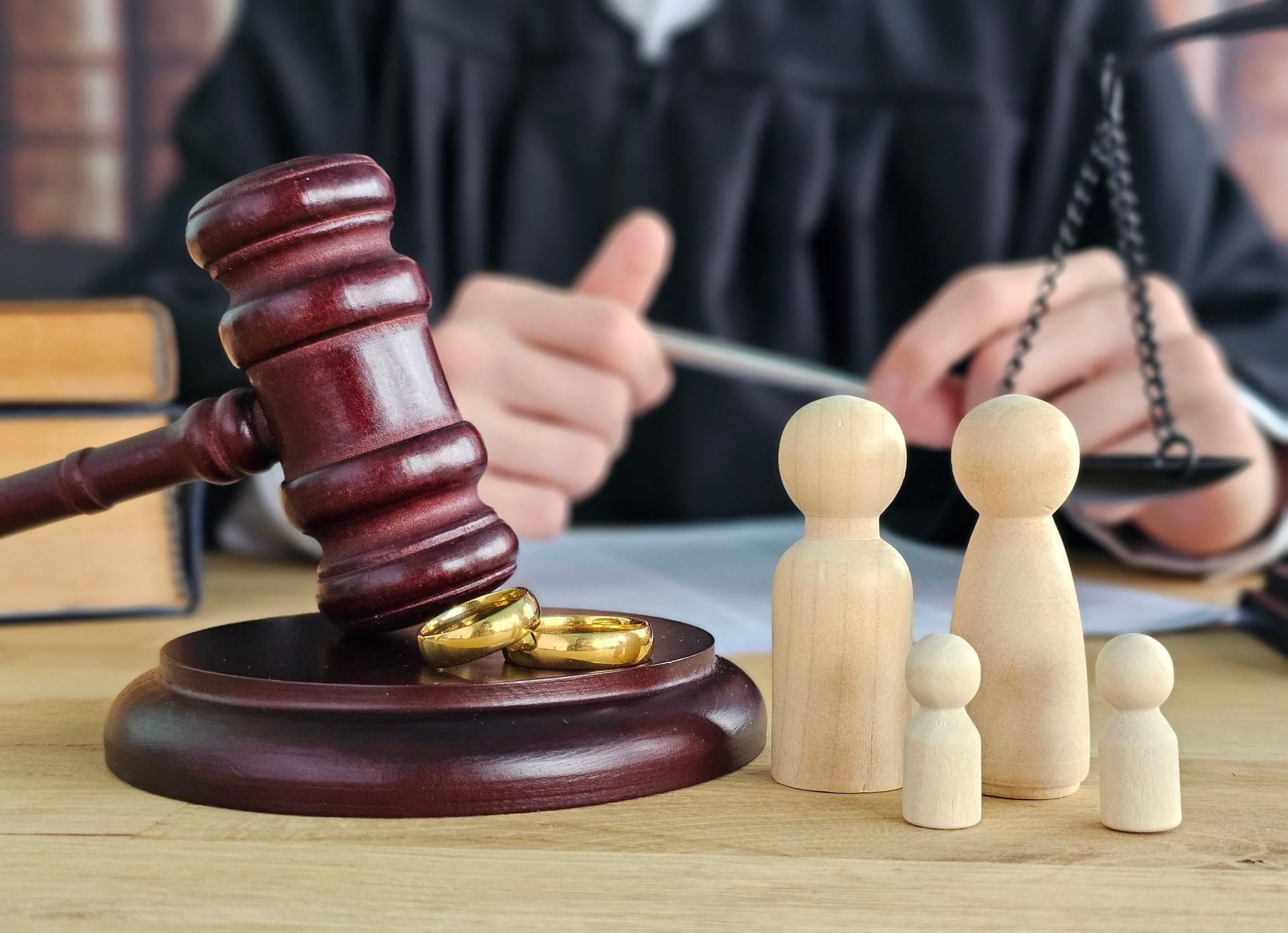 Marteau de juge, balance et figurines en bois sur un bureau.