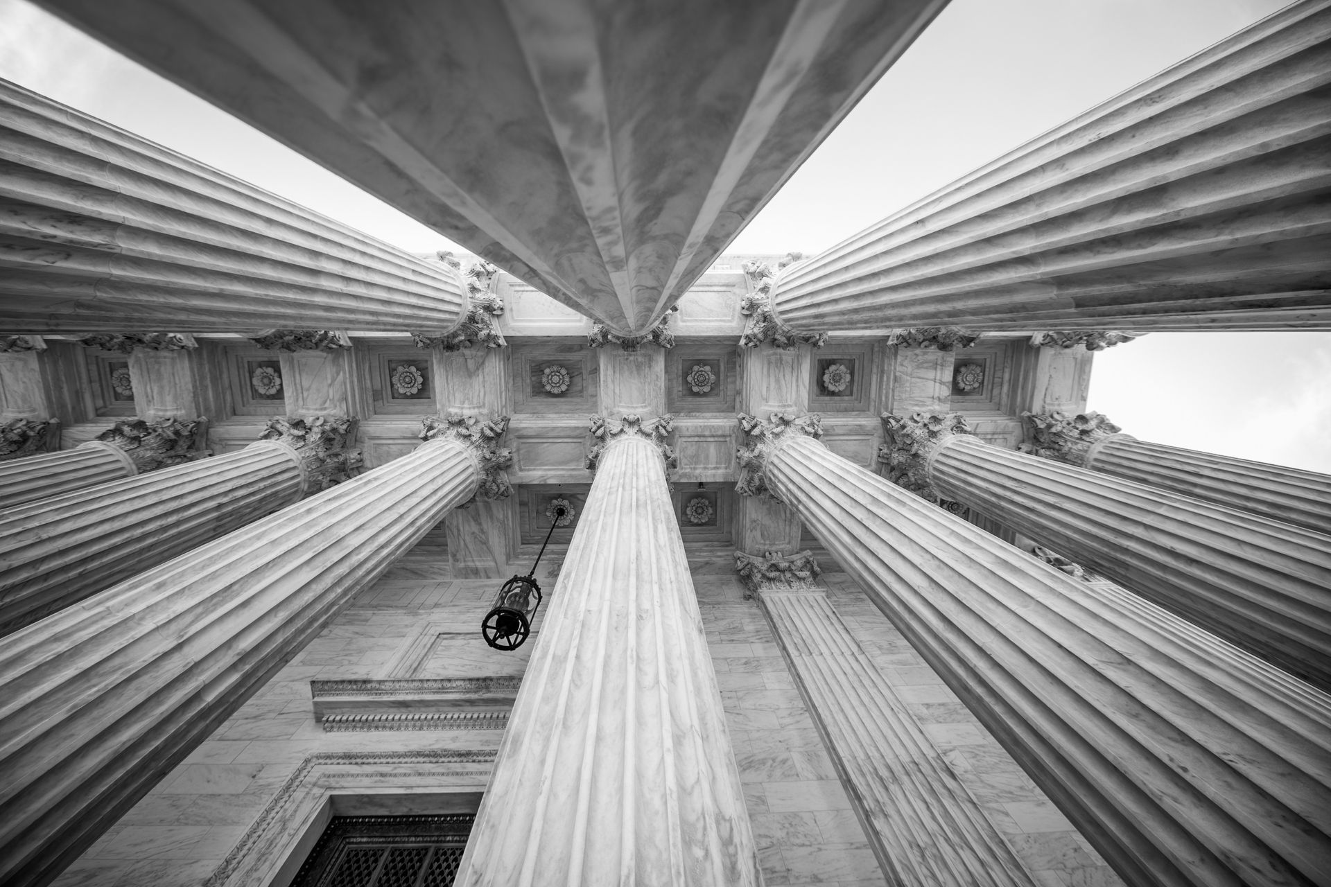 Vue en noir et blanc d'un intérieur majestueux à colonnes, avec un plafond orné.