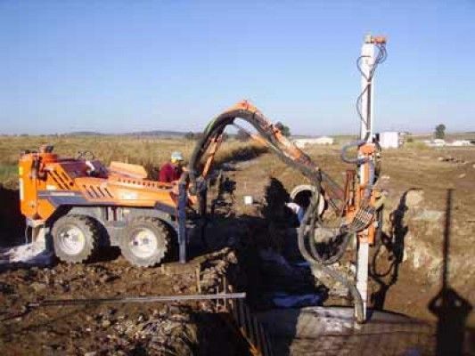 Un hombre está trabajando en una máquina en un campo.
