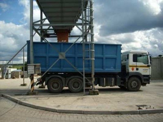 Un camión volquete azul está estacionado en un estacionamiento