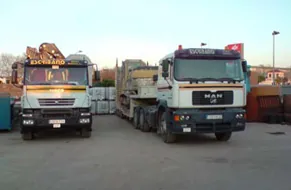 Dos camiones de carga están estacionados uno al lado del otro en un estacionamiento.