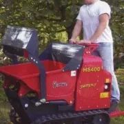 Un hombre viaja en un camión volquete rojo sobre vías.