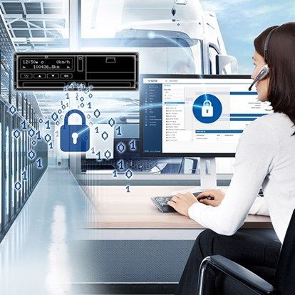 Una mujer está sentada frente a una computadora con unos auriculares puestos.