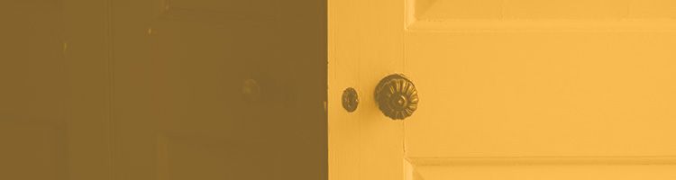 Gros plan sur une porte jaune avec une poignée ronde et foncée et un petit judas.