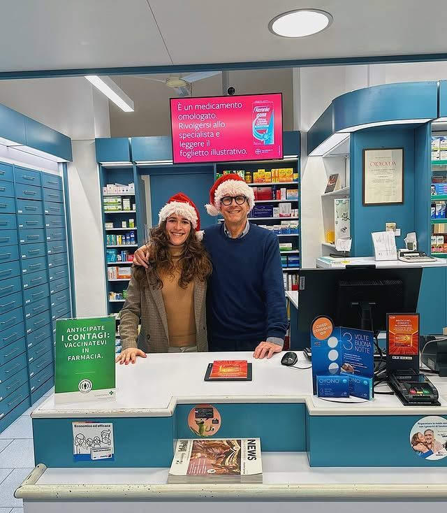 Un uomo e una donna posano per una foto in una farmacia.