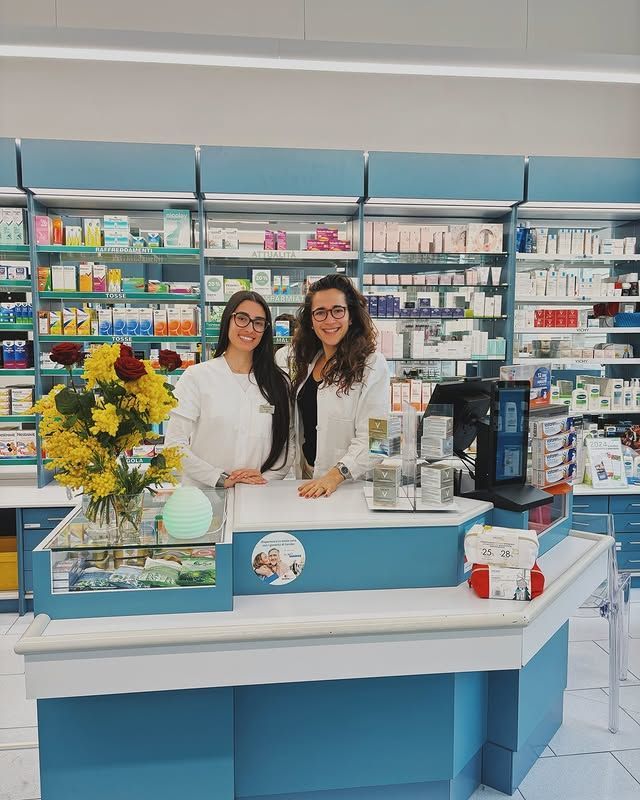 Due donne sono in piedi al bancone di una farmacia.