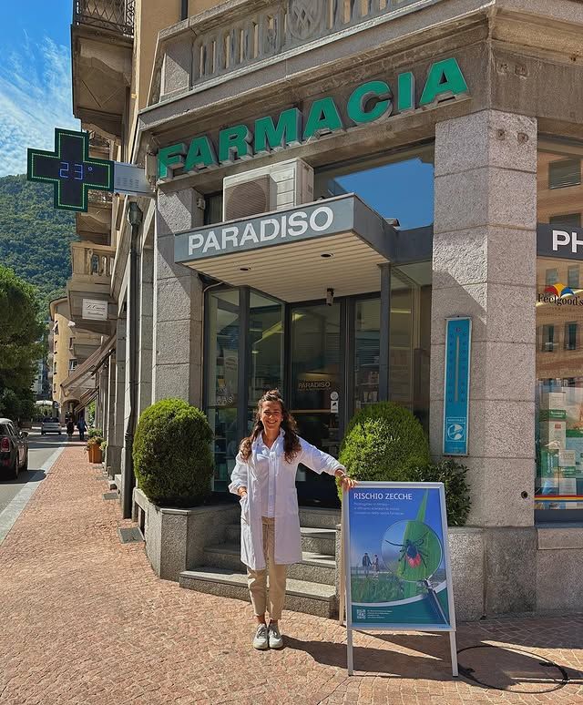 Una donna è in piedi davanti a un negozio della farmacia Paradiso