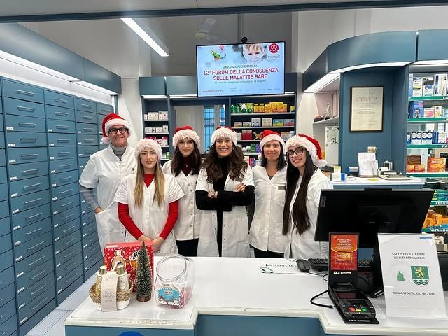 Un gruppo di persone che indossano cappelli da Babbo Natale si trova in una farmacia.