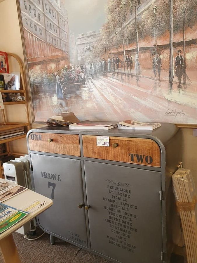 Un rangement gris avec deux tiroirs en bois.