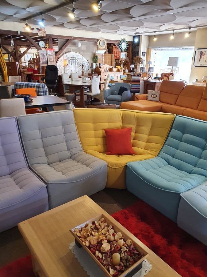 Plusieurs canapés de couleurs formant d'un angle arrondi.