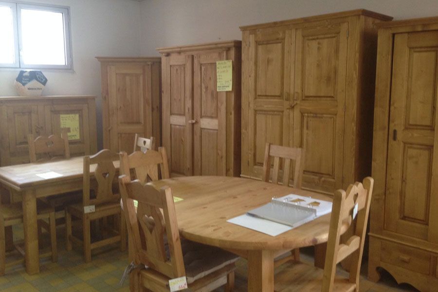 Plusieurs penderies en bois derrière des tables.