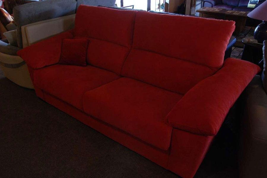 Un canapé rouge avec un grand dossier.