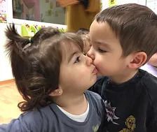 Un chico y una chica se besan en una habitación.