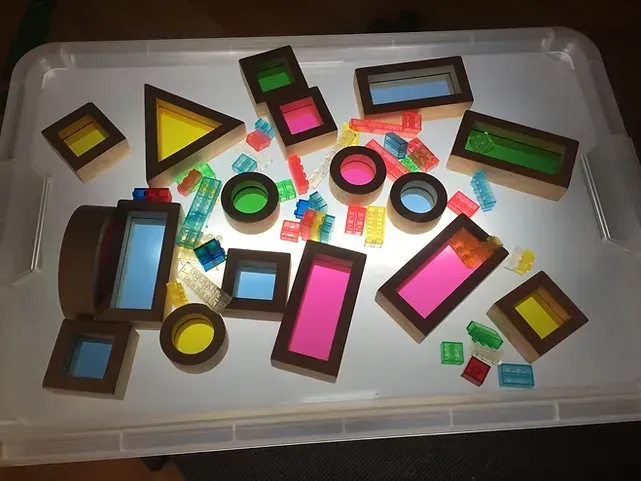 Un recipiente de plástico lleno de bloques Lego de colores.