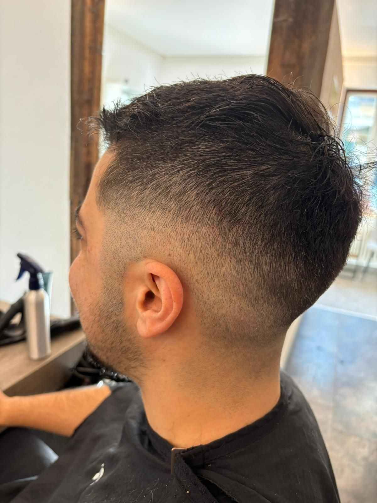 Nahaufnahme einer geflochtenen, lockigen Hochsteckfrisur, verziert mit kleinen weißen Seesternen und Perlenhaarnadeln.