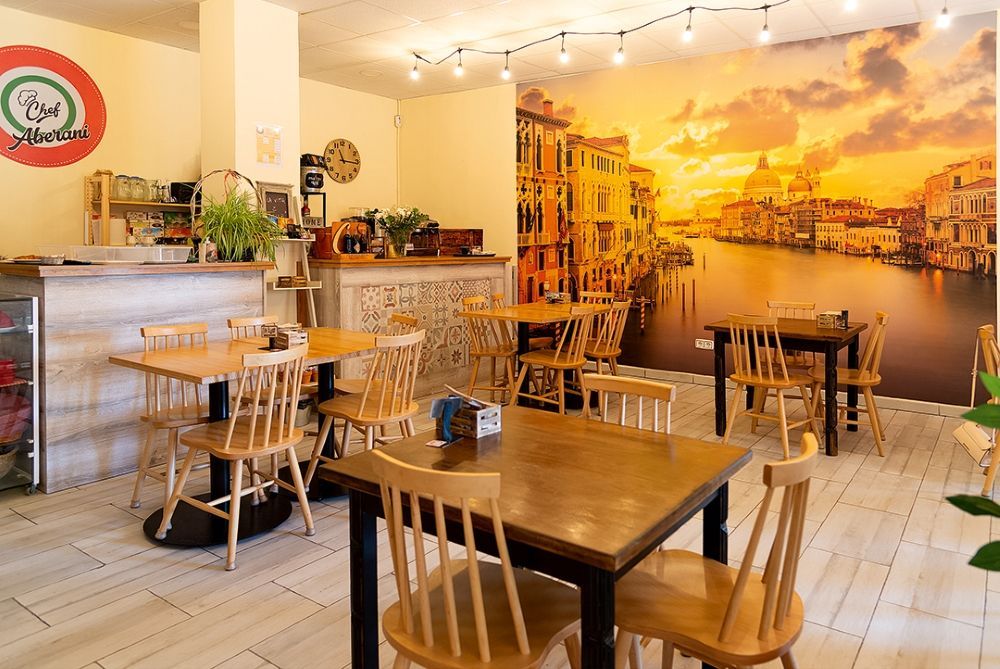 Un restaurante con mesas y sillas y un cuadro grande en la pared.