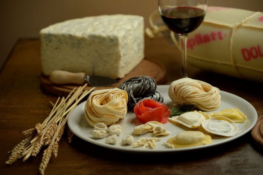 Un plato de pasta y una copa de vino en una mesa