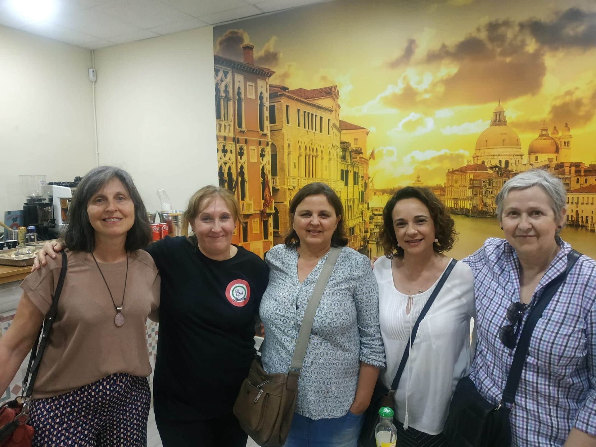 Un pequeño pueblo en la cima de una colina con montañas al fondo.