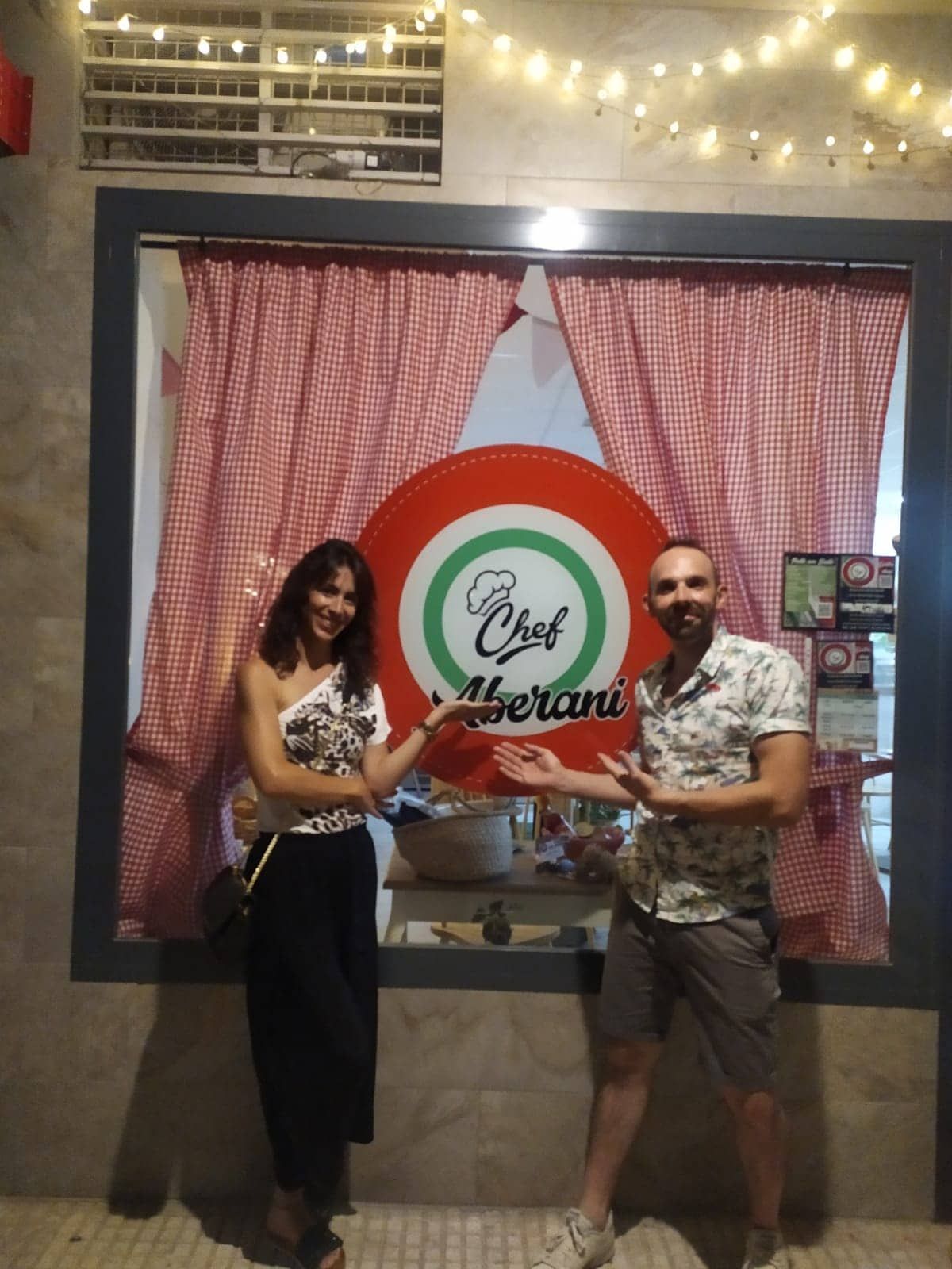 Un hombre y una mujer de pie frente a una ventana que dice chef.