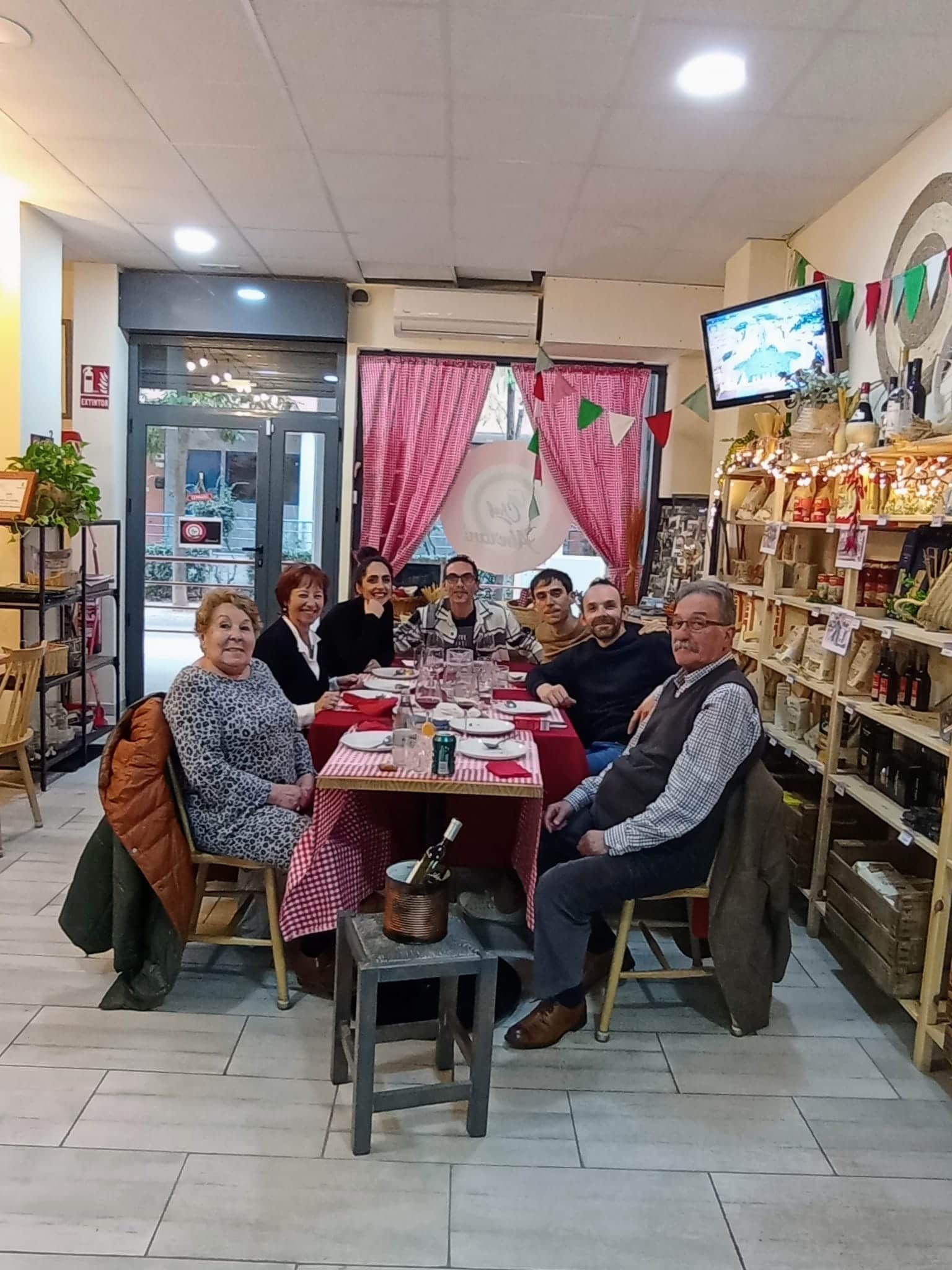 Un grupo de personas están sentadas alrededor de una mesa en un restaurante.
