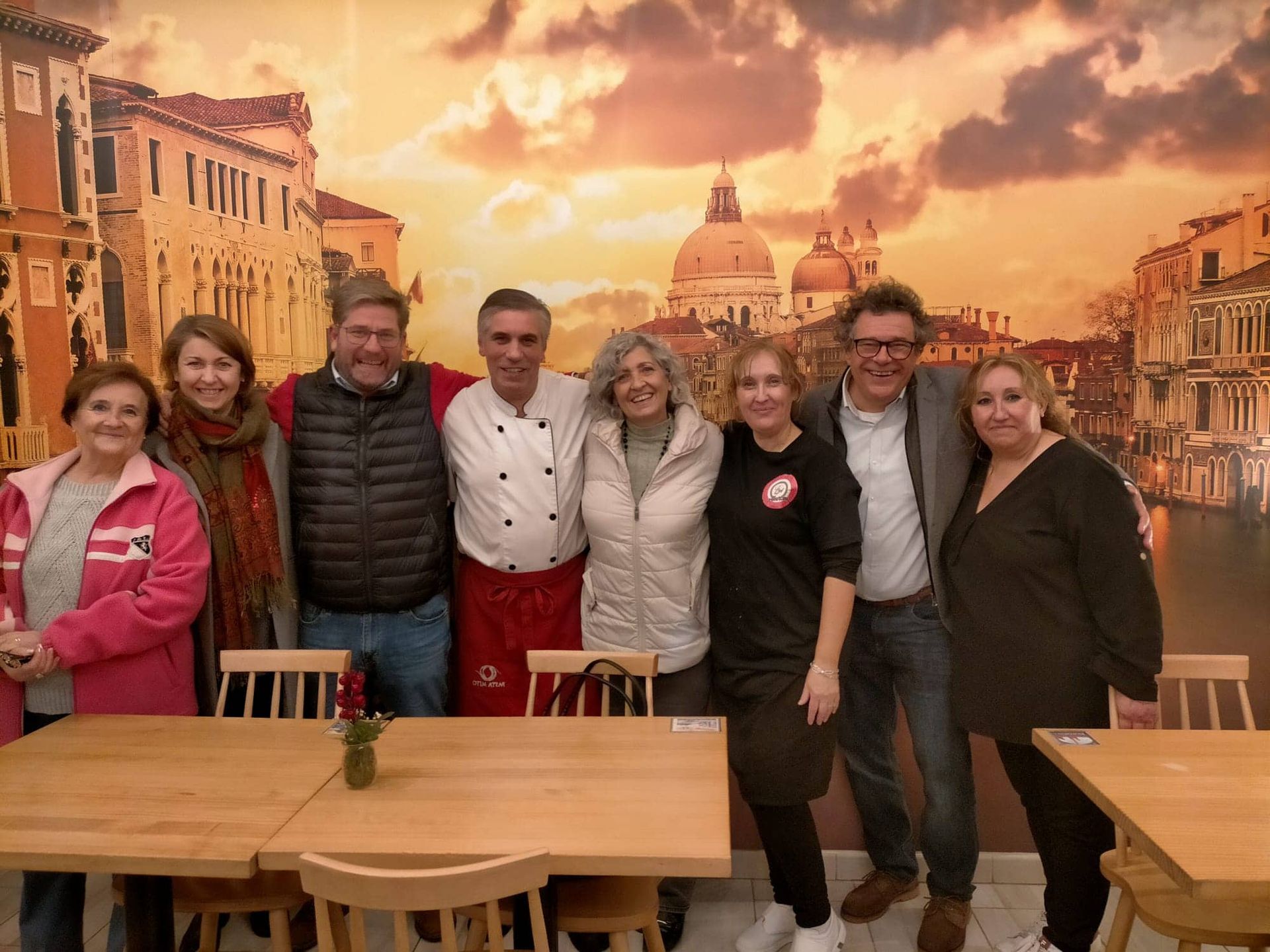 Un gran edificio con arcos y un árbol de Navidad delante.