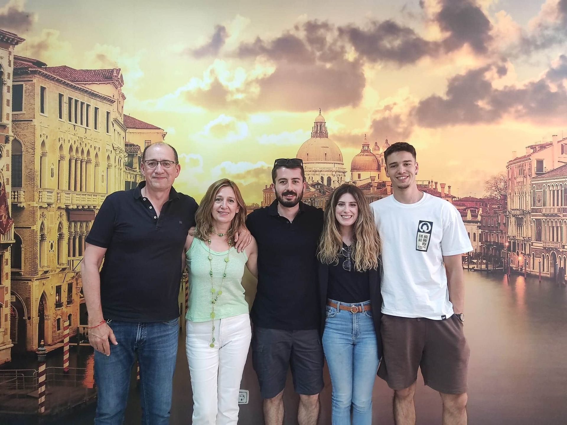 Un grupo de personas posando delante de una imagen de Venecia.