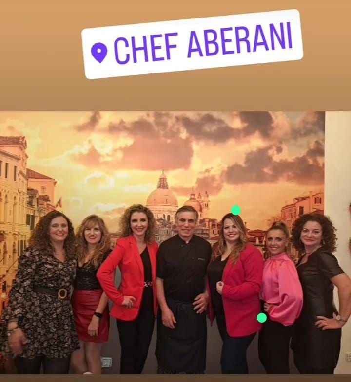 Un grupo de personas de pie frente a un cartel que dice Chef Aberani.