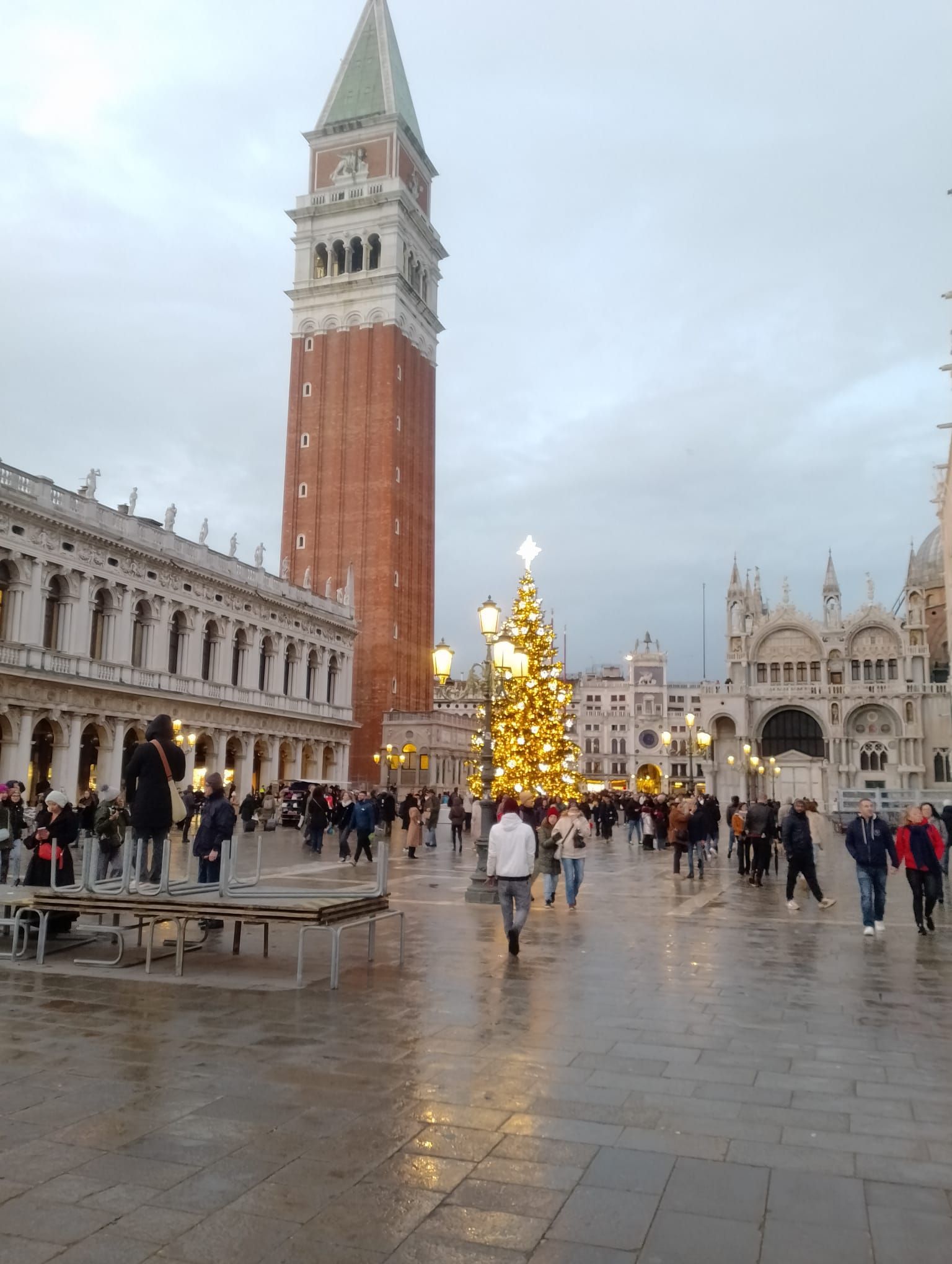 Un pequeño pueblo en la cima de una colina con montañas al fondo.