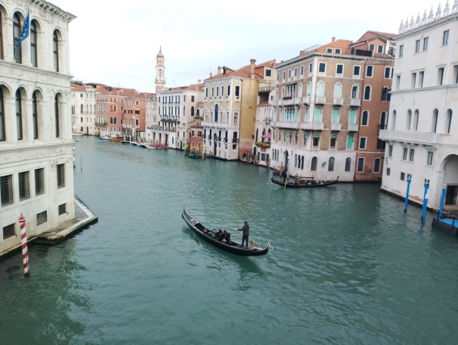 Un hombre viaja en góndola por un canal en Venecia.