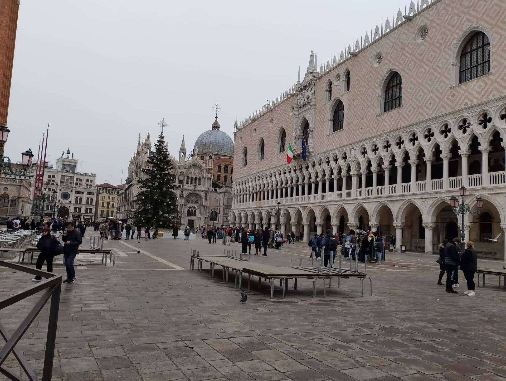 Un gran edificio con arcos y un árbol de Navidad delante.