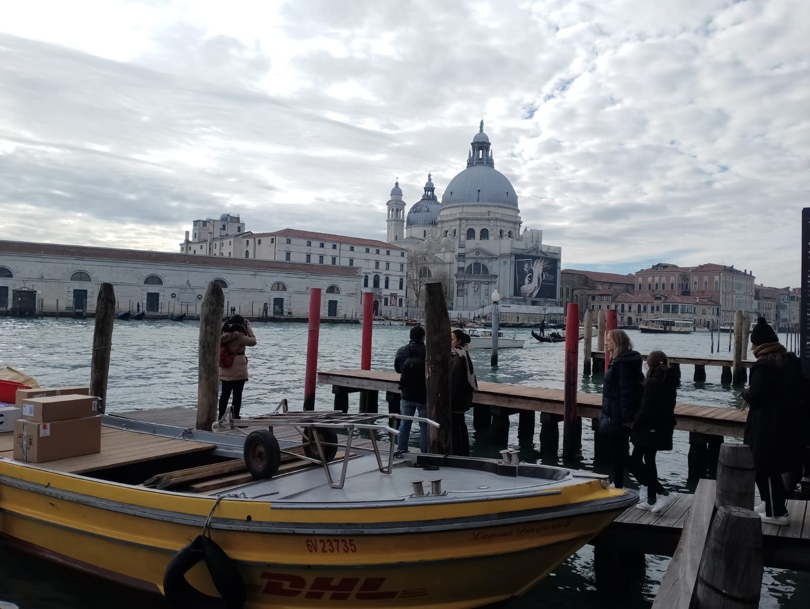 Un barco amarillo de DHL está atracado en un muelle.