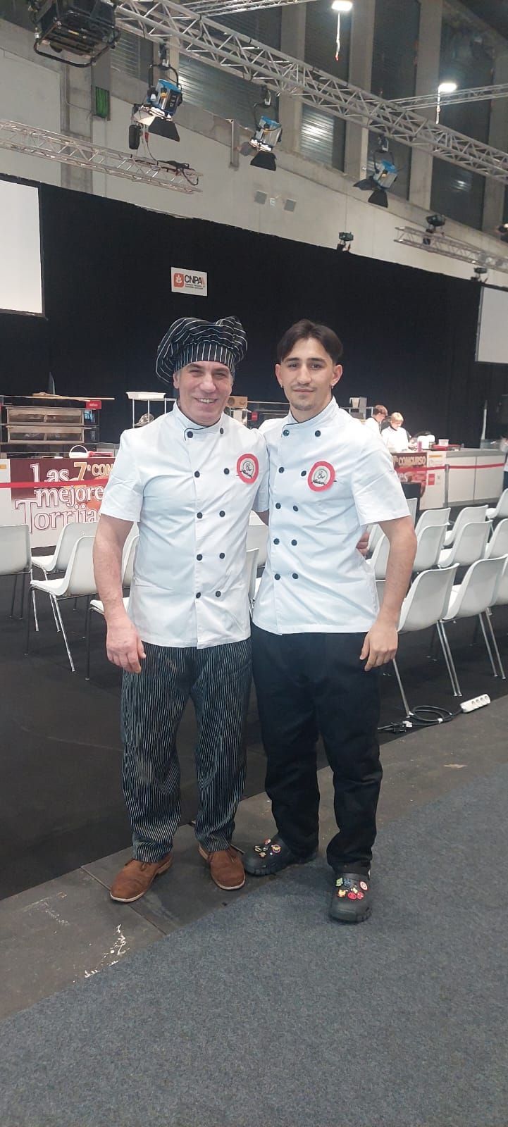 Dos hombres parados uno al lado del otro en una habitación con un cartel que dice 