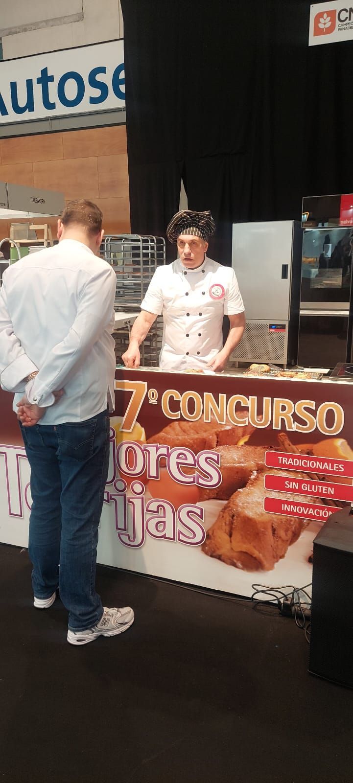 Un hombre parado frente a un cartel que dice 7 concurso