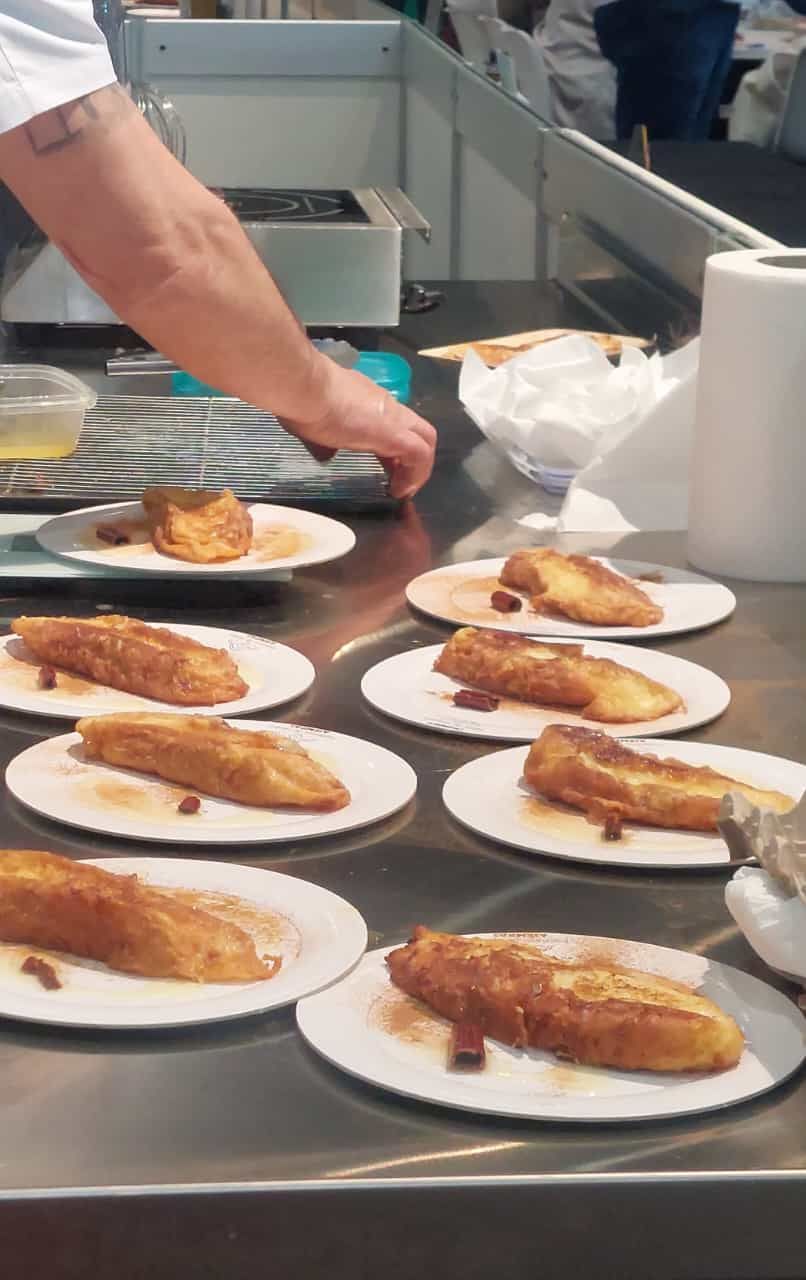 Una persona está preparando comida en platos sobre un mostrador.
