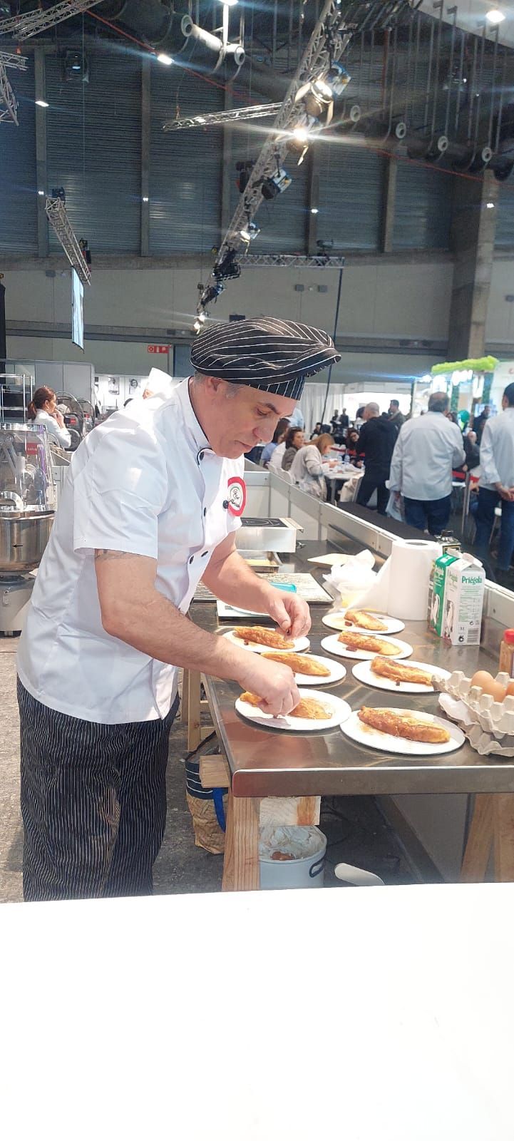 Un hombre está preparando comida en una mesa en una cocina.