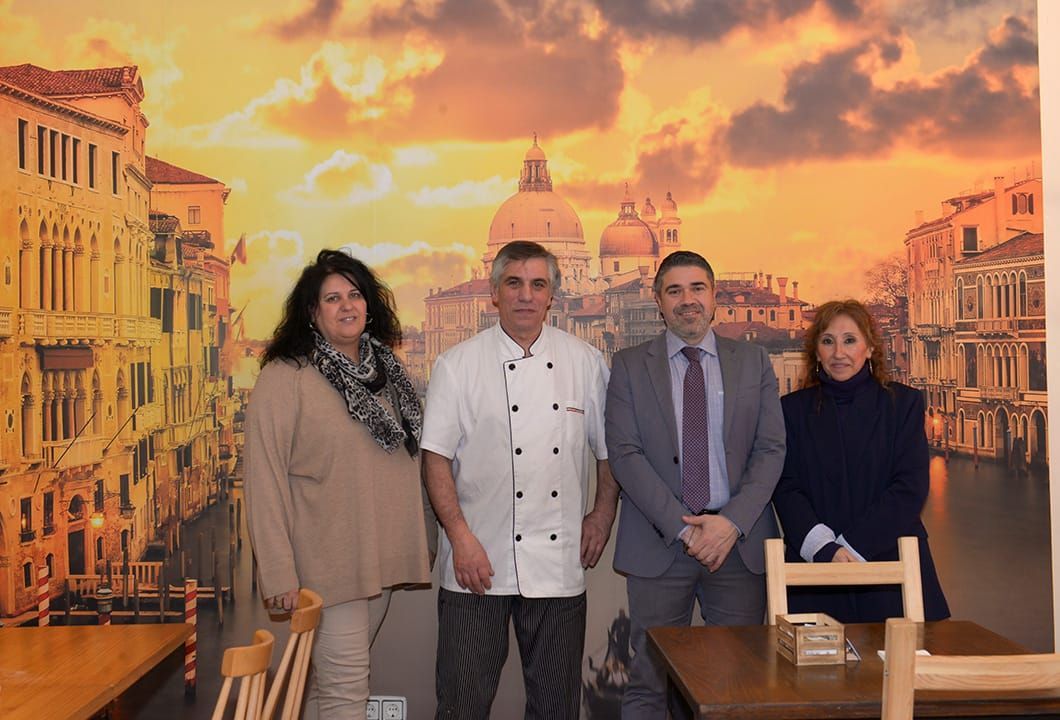 Un grupo de personas de pie frente a una imagen de Venecia.
