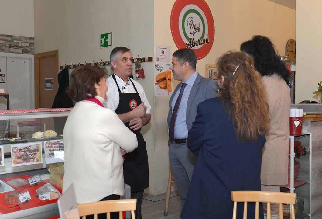 Un grupo de personas de pie en una habitación con una señal de salida verde en la pared.