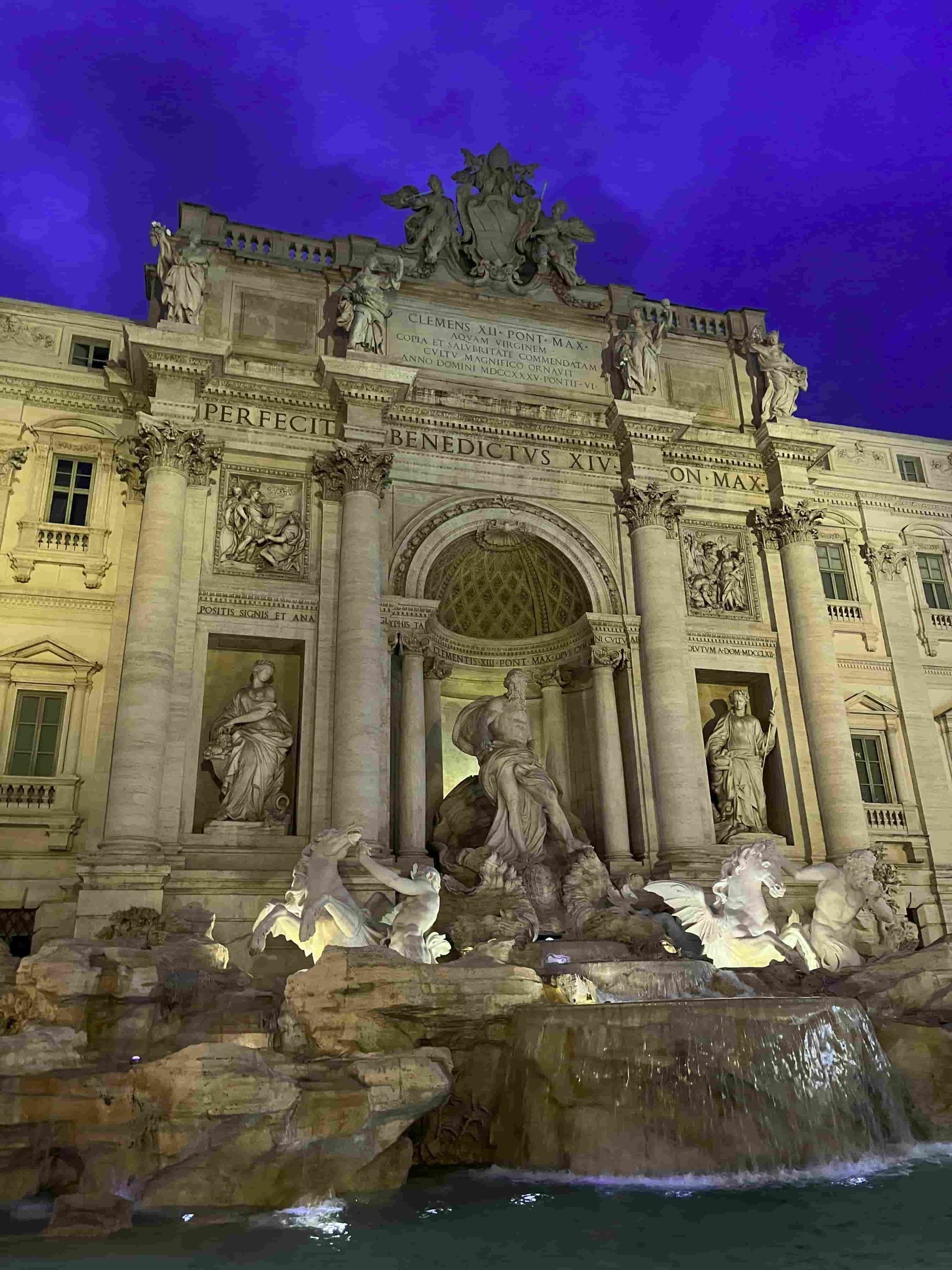 Un gran edificio con una fuente delante.