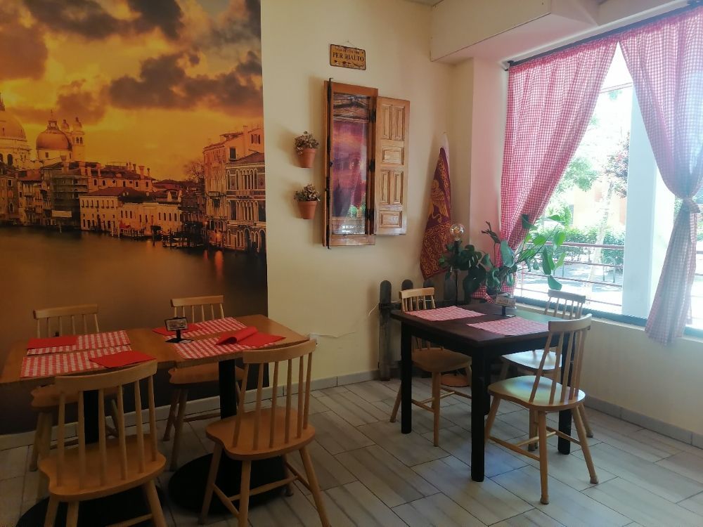 Un comedor con mesas y sillas y un cuadro en la pared.