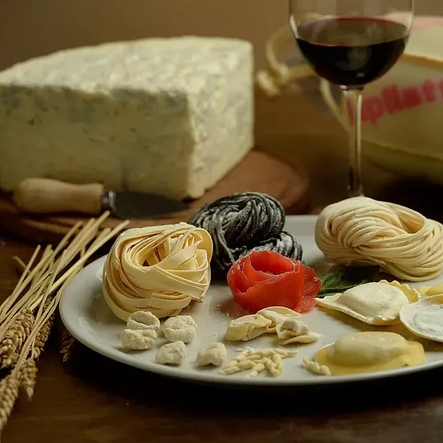 Un plato de pasta y una copa de vino en una mesa