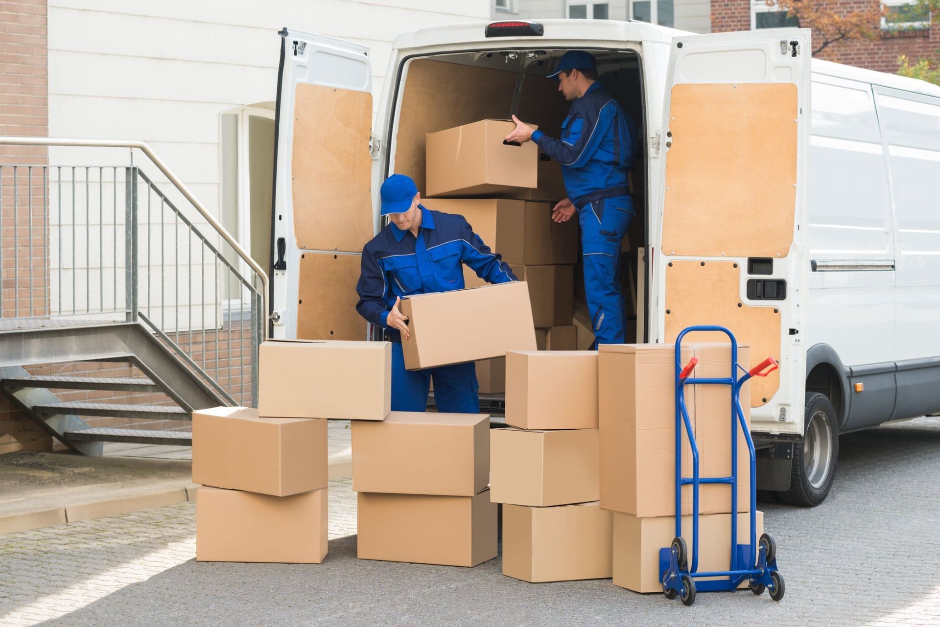 Dos hombres están cargando cajas en un camión de mudanzas.