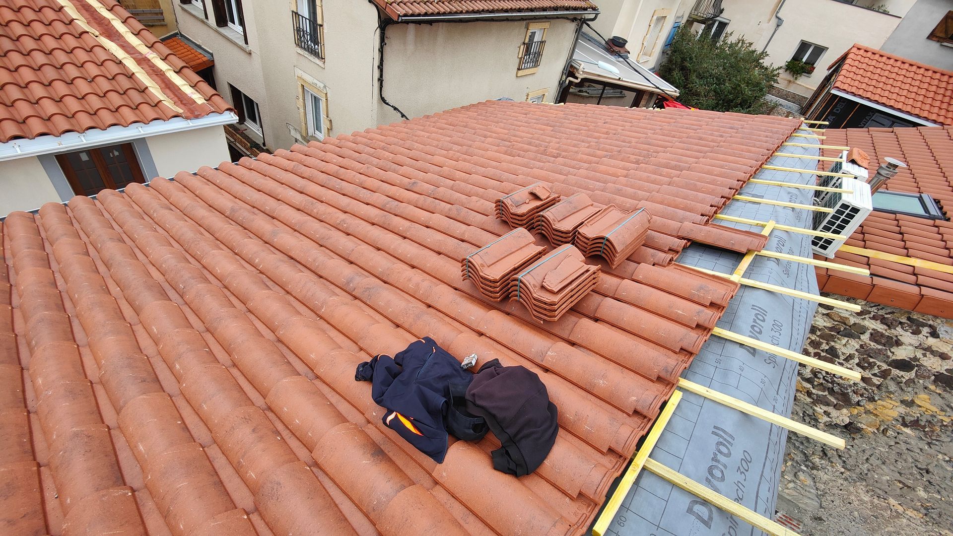 Toiture inachevée avec des piles de tuiles