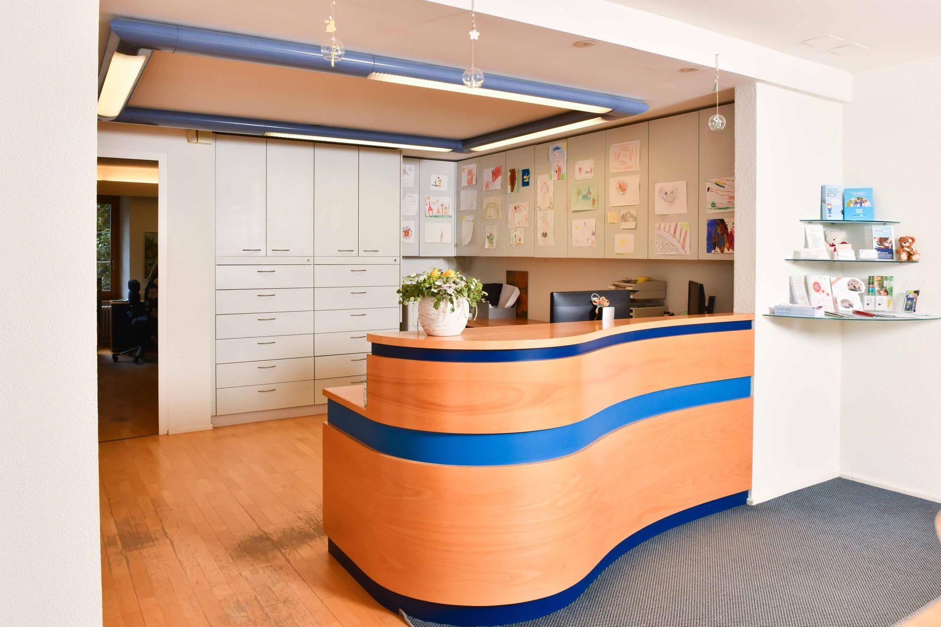 Ein Empfangsbereich mit einem Holztresen und blauen Zierleisten