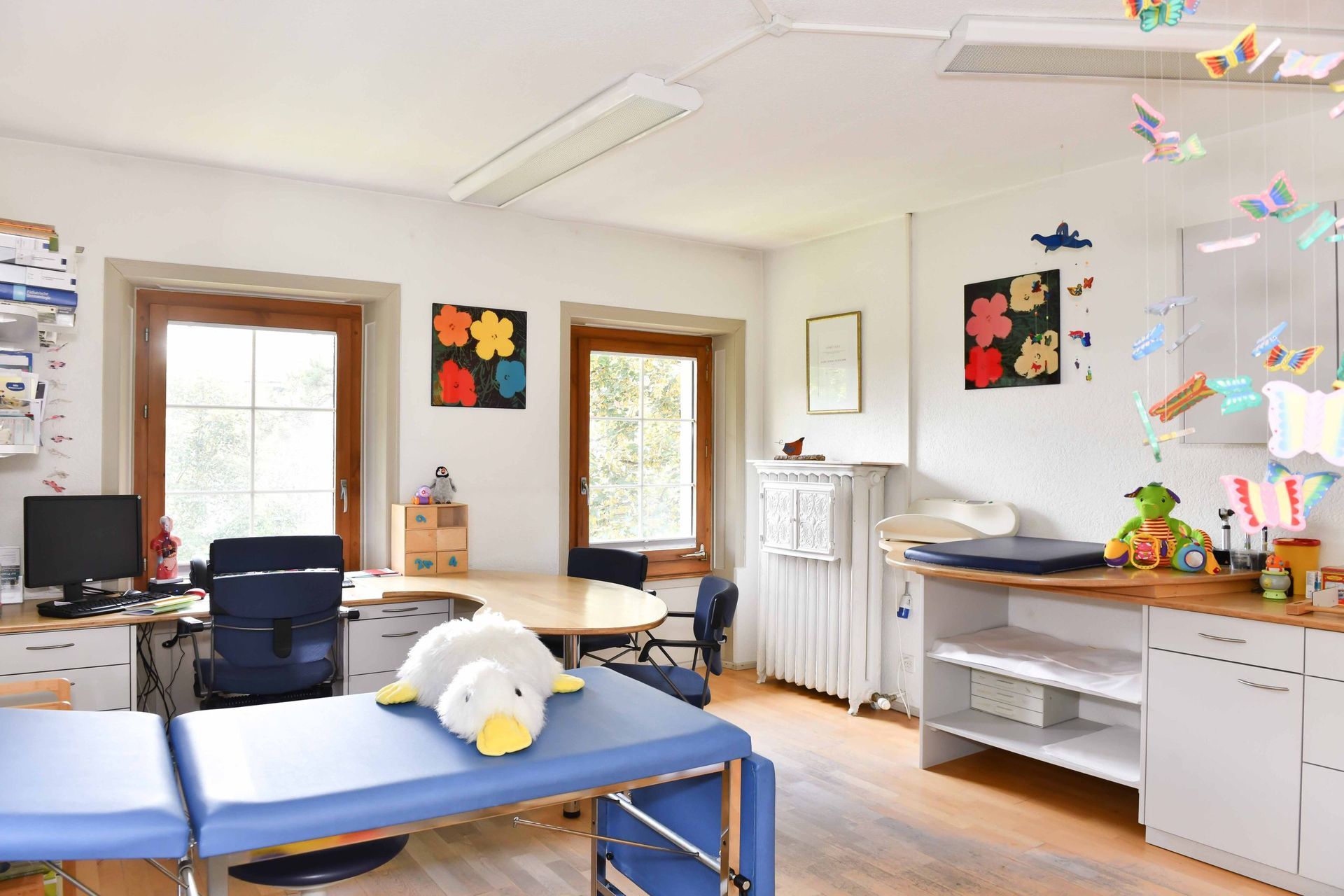 Eine Arztpraxis mit einem blauen Tisch und einem Stofftier darauf.