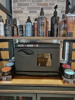 Un estante lleno de botellas de productos para el cabello y un calentador de toallas.