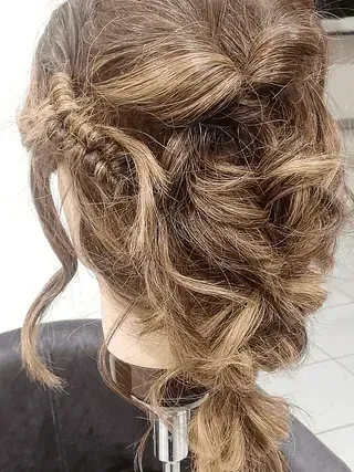 Una mujer lleva el cabello recogido en una cola trenzada.