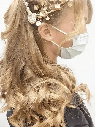 Una mujer que lleva una máscara facial y una corona de flores en el pelo.